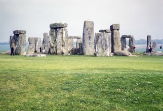 People exploring the standing stones at the Neolithic site of Stonehenge, Wiltshire, England, UK