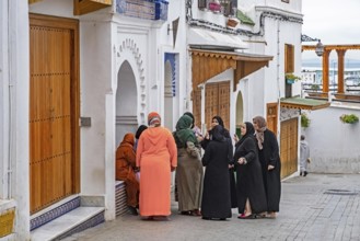 Moroccan Muslim women in traditional Islamic dress wearing hijab in medina of the city Tangier,