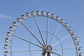 Ferris wheel with Hamburg city coat of arms against a blue sky in summer on Hamburg Cathedral,