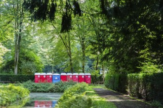 A row of red and blue toilet blocks in the park after an event, Düsseldorf, Germany, Europe