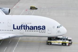 Lufthansa Airbus A380-800 being towed with push back truck on taxiway towards Lufthansa maintenance