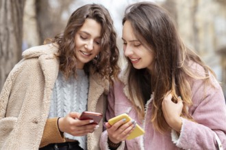 Medium shot women holding smartphones