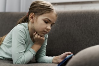 Little girl playing smartphone home