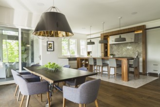 Chrome and walnut wood table with charcoal linen armchairs, large black and gold industrial style
