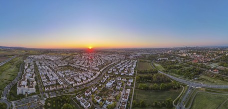 The sun rises over the Riedberg and Niederursel districts of Frankfurt in the north-west. (Aerial