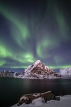 Green northern lights reflected in fjord, steep mountains, aurora borealis, winter, Reine,