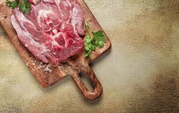 Raw steak, veal neck on the bone, fresh meat, on a cutting board, with spices, top view, without
