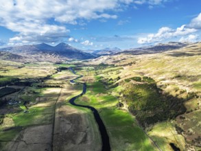 Farms and Mountains over River Dochart and Road A85 from a drone, Perthshire, Scotland, UK