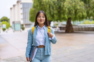 Portrait of a chinese university student in the campus standing proud looking at camera
