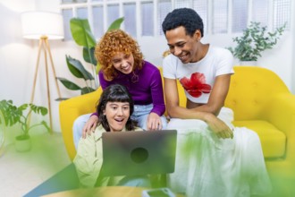 Multiracial lgtb friends using laptop sitting together on the sofa
