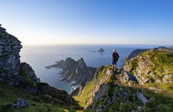 Mountaineer on the summit of Måtind or Måtinden, view of picturesque coastal landscape, rocky coast