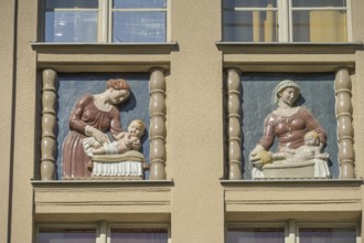 Mothers looking after their babies, relief on an old building, former woman's and children's