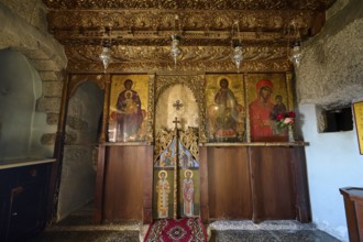 An altar in a church with religious icons, carved wood and candle lighting, Apokalipsis Monastery,