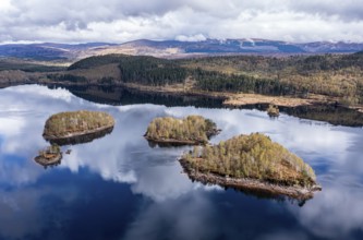 Clouds reflected in lake Loch Garry, islands on the mirrored sky, scottish highlands, aerial view,