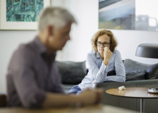 Symbolic photo on the subject of problems in a partnership. An older woman and an older man sitting