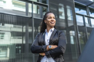 Latin cuban modern businesswoman with long braids standing proud outside modern building
