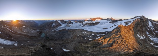 Atmospheric sunrise in a picturesque mountain landscape, alpenglow, aerial view, mountain hut
