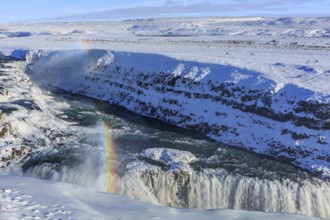 Large waterfall in a gorge in the snow, winter, sunny, rainbow, spray, Gullfoss, Golden Circle,