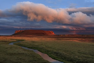 Volcanic crater reflected in stream, lava field, cloudy mood, midnight sun, summer, Burfellshraun,