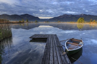 Mountains reflected in lake, jetty and boat, morning light, spring, Loisach-Lake Kochel moor,