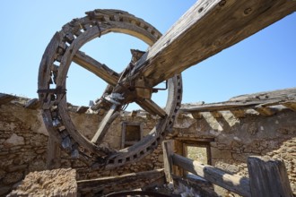 Large wooden cogwheel and wooden beams in an abandoned mill, under the open sky, windmill, ruin,