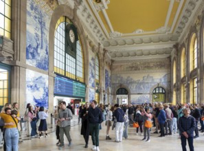 Tour groups viewing historic azulejos tiles, Sao Bento railway station building, city of Porto,