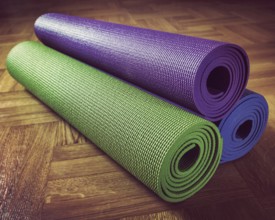 Vintage retro effect filtered hipster style image of Yoga mats on wooden floor