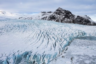 Snow-covered icebergs in the Fjallsarlon glacier lagoon, with the Öraefajökull glacier behind,