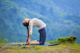 Yoga, outdoors young beautiful slender woman yoga instructor doing camel pose Ustrasana asana