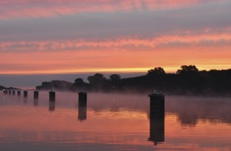 Jetty, dolphins, ship's switch at sunrise and fog on the Kiel Canal, Schleswig-Holstein, Germany,