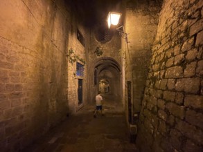Boy in an alley in the old town of Kotor, historical, night, eerie, Bay of Kotor, Adriatic Sea,