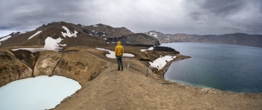Tourist at the crater rim, crater lake Víti and Öskjuvatn in the crater of Askja volcano, volcanic