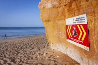 ROCKFALL UNSTABLE CLIFFS, KEEP A SAFE DISTANCE is written in English on a warning sign in Portugal
