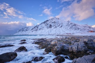 Beach of Norwegian sea on rocky coast in fjord on sunset in winter. Vareid beach, Lofoten islands,