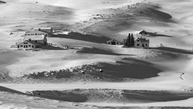 Farmhouse in snow-covered hilly landscape, near Akureyri, black and white photo, Northern Iceland