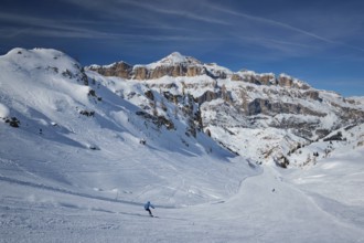 View of a ski resort piste with people skiing in Dolomites in Italy. Ski area Arabba. Arabba,