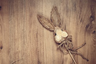 Easter bunny made of straw, on a wooden background, top view, no people