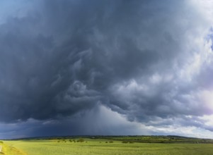 Thunderstorm cell with rainbow over fields near Krebs in the Osterzgebirge, Krebs, Saxony, Germany,