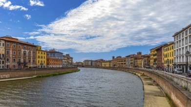 Rows of houses with pastel-coloured facades to the left and right of the River Arno, Pisa, Tuscany,