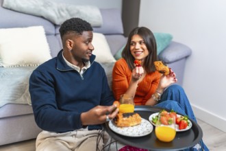 Couple sharing a cozy breakfast at home, enjoying fresh fruit, pastries, and juice, creating a warm