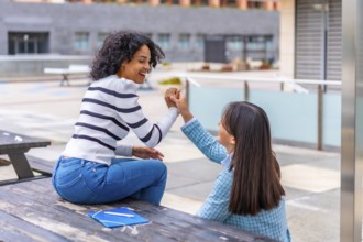 Students female multi-ethnic friends sitting in the campus of the university together talking and
