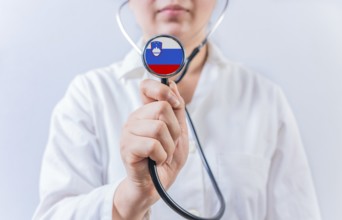Female doctor holding stethoscope with Slovenia flag. National health system of Slovenia