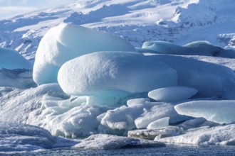 A large block of ice is surrounded by smaller pieces of ice, Jokulsarlon, Iceland, Europe