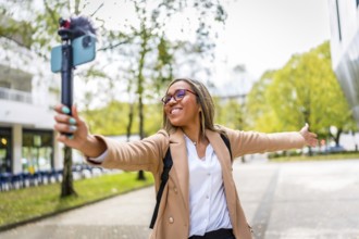 Latin female content creator opening arms showing a city to the audience while recording a video