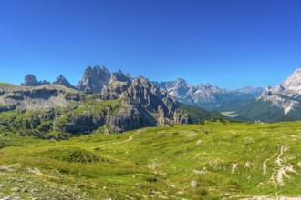 Breathtaking landscape of tre cime di lavaredo peaks towering above lush green meadows in the