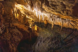 Beautiful stalactites reflecting on the martel lake in the caves of drach, mallorca, spain