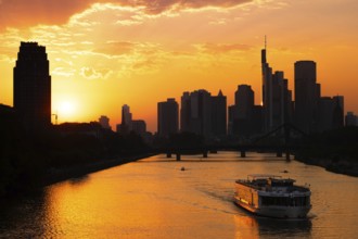 The sun sets behind the Frankfurt banking skyline as a PRIMUS LINE ship travels along the Main,