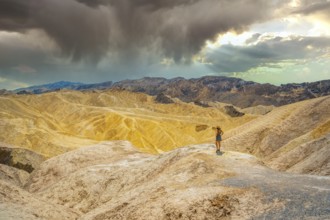 A young woman in dress enjoying the view of the viewpoint of Zabriskie Point, California. United