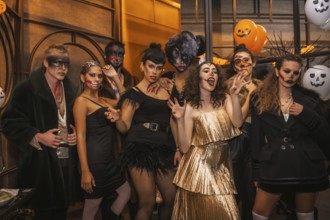 Halloween party with friends in a disco nightclub, group of friends sitting on a sofa in makeup and