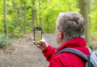 Symbolic image Hiking with smartphone and hiking app, navigation on hiking trails, digital hiking